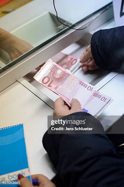 Syrian refugee Khouloud Alhraki receive money in the registration office at the refugee center on December 10, 2013 in Friedland, Germany. She gets a...