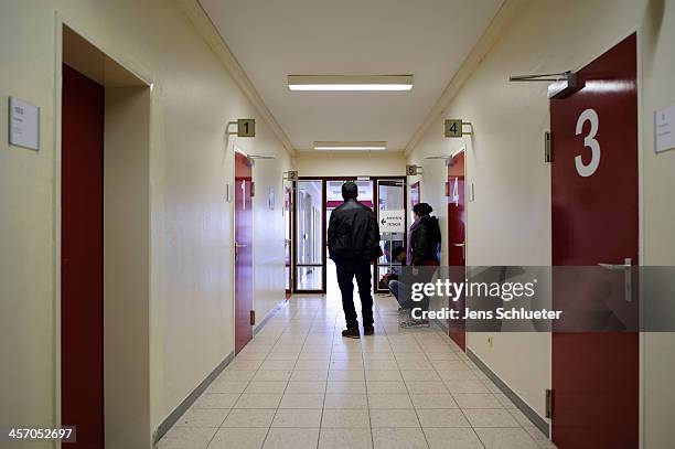 Unidentified refugees are seen in a gear in front of the registration office at the refugee center on December 10, 2013 in Friedland, Germany....