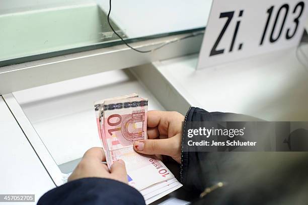 Syrian refugee Khouloud Alhraki receive money in the registration office at the refugee center on December 10, 2013 in Friedland, Germany. She gets a...