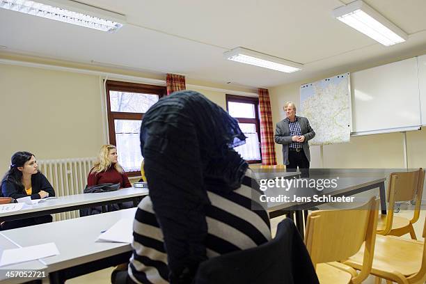 Syrian refugees Khouloud Alhraki , Alia Alhraki and a unidentified Syrian refugee sit in a "Welcome in Germany" seminar at the refugee center on...