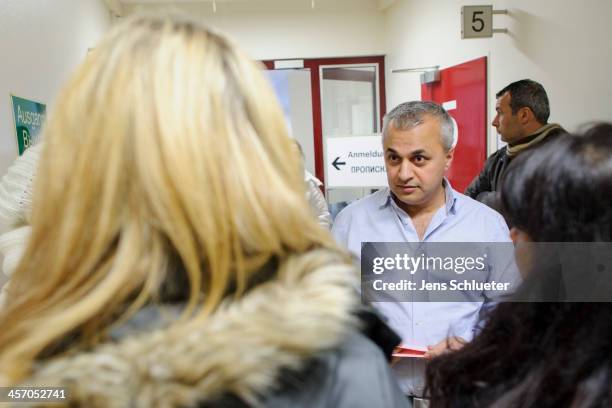 Translator Samal Osman speaks with unidentified Syrian refugees in the registration office at the refugee center on December 10, 2013 in Friedland,...