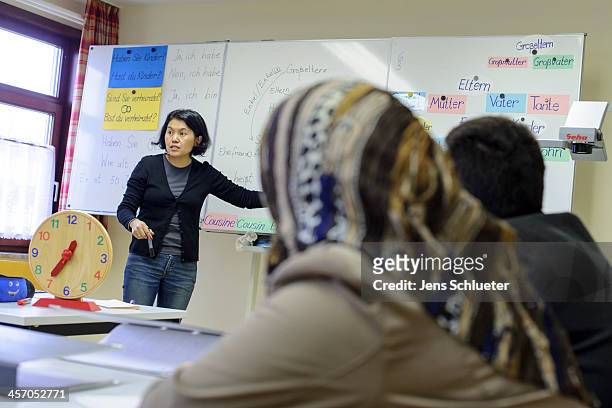 Unidentified Syrian refugees participate in a German language class with German teacher Asiel Schaimkulova at the refugee center on December 10, 2013...