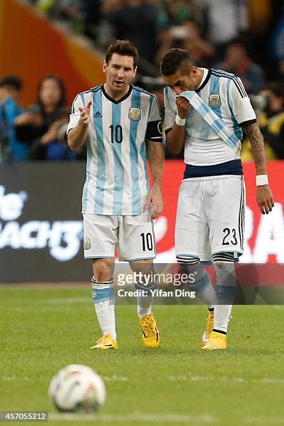 Lionel Messi of Argentina speaks to Alvaro Pereira of Argentina during a match between Argentina and Brazil as part of 2014 Superclasico de las...