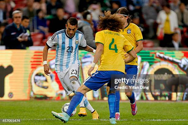 David Luiz of Brazil and Roberto Pereyra of Argentina battle for the ball during a match between Argentina and Brazil as part of 2014 Superclasico de...