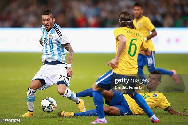 Luiz Gustavo of Brazil competes the ball with Pereyra of Argentina during Super Clasico de las Americas between Argentina and Brazil at Beijing...