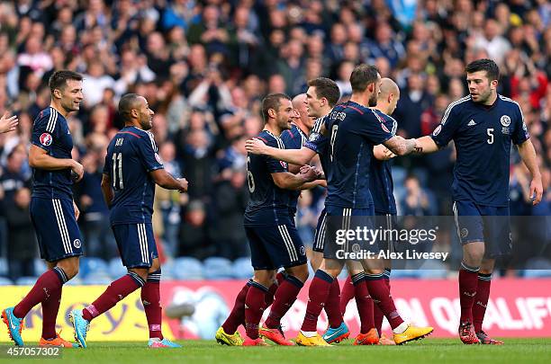 Shaun Maloney of Scotland celebrates with team mates after his shot went in off Akaki Khubutia of Georgia for an own goal to open the scoring during...