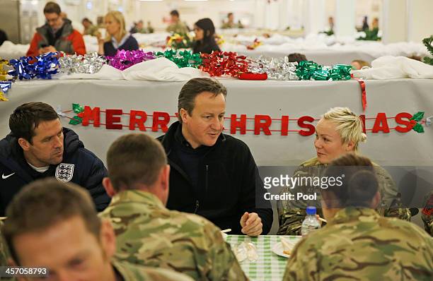 Britain's Prime Minister David Cameron eats breakfast with British soldiers during a visit to Camp Bastion on December 16, 2013 near Lashkar Gah, the...