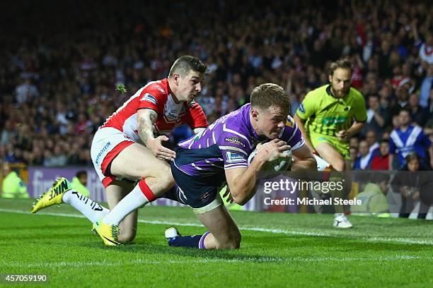 Joe Burgess of Wigan scores the opening try despite the attentions of Mark Percival of St Helens during the First Utility Super League Grand Final...