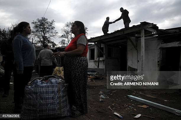 Two women speak as members of the Roma community help dismantle a Roma camp in the Serb-majority town of Leposavic in northern Kosovo on December 16,...