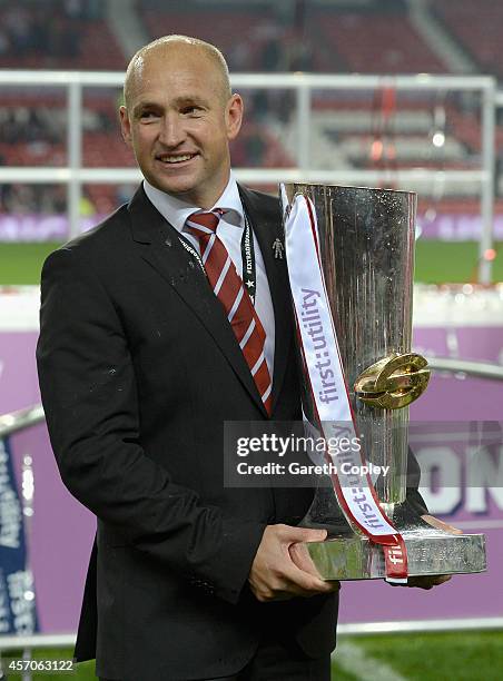 St Helens coach Nathan Brown lifts the trophy after winning the First Utility Super League Grand Final between St Helens and Wigan Warriors at Old...