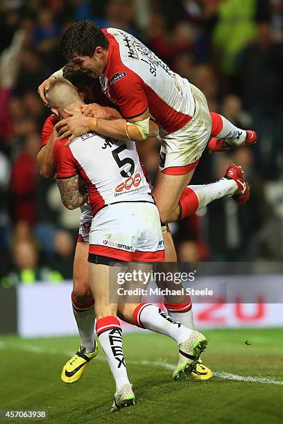 Tom Makinson of St Helens is smothered by Louie McCarthy-Scarsbrook and Adam Swift after scoring the crucial second try during the First Utility...