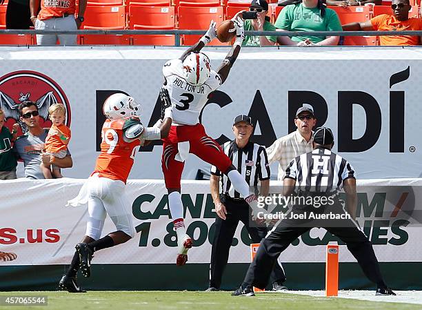 Corn Elder of the Miami Hurricanes prevents Johnny Holton of the Cincinnati Bearcats from catching the ball for a touchdown during fourth quarter...