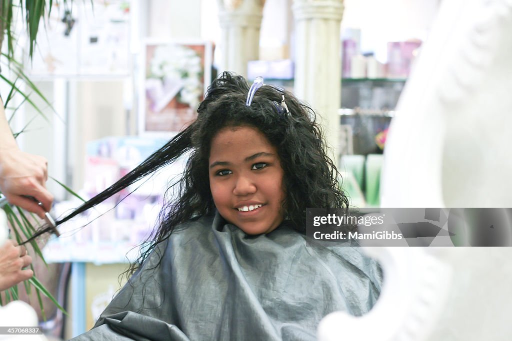 Girl is hair cut at the beauty salon