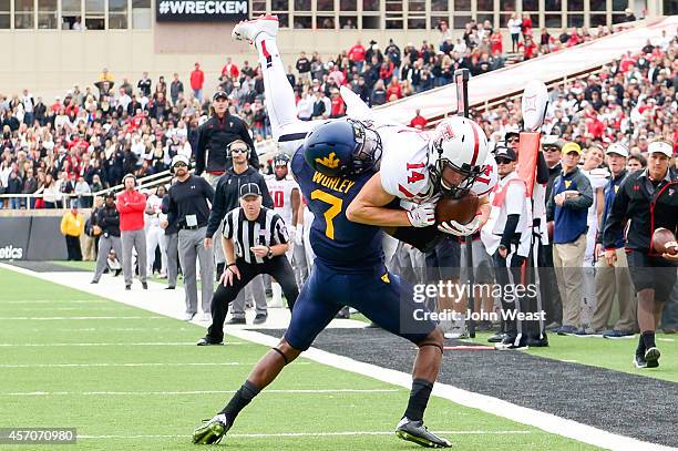 Dylan Cantrell of the Texas Tech Red Raiders comes down with the ball while being defended by Daryl Worley of the West Virginia Mountaineers on...