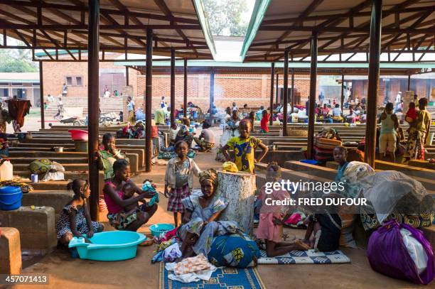 People are pictured at a refugee camp set in the garden of Notre Dame de Fatima church, in Bangui on December 16, 2013. AFP PHOTO / FRED DUFOUR