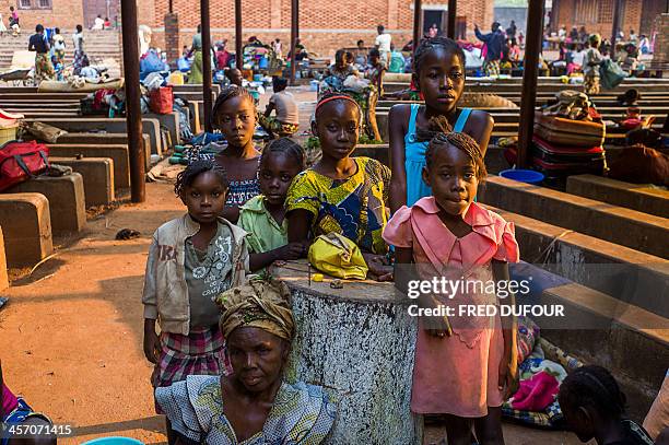 People pose at a refugee camp set in the garden of Notre Dame de Fatima church, in Bangui on December 16, 2013. AFP PHOTO / FRED DUFOUR