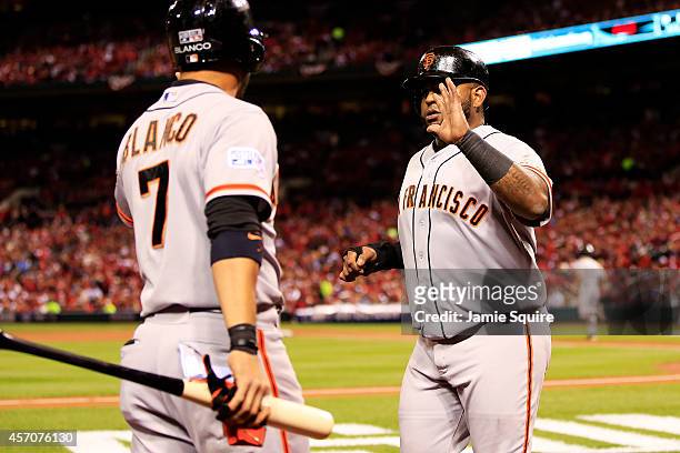 Pablo Sandoval celebrates with Gregor Blanco after scoring on a single by Travis Ishikawa of the San Francisco Giants in the second inning against...