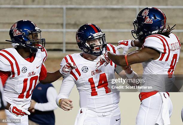 Bo Wallace, Vince Sanders and Quincy Adeboyejo of the Mississippi Rebels celebrate after Wallace scored a four-yard touchdown during the first half...