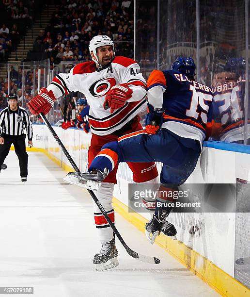 Cal Clutterbuck of the New York Islanders is hit by Jay Harrison of the Carolina Hurricanes during the third period at the Nassau Veterans Memorial...