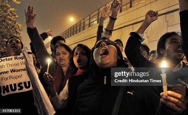 Students take part in a candle-light vigil to mark the first anniversary of Delhi gang rape at a spot in Munirka from where the victim got on bus on...