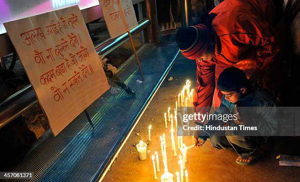 Students take part in a candle-light vigil to mark the first anniversary of Delhi gang rape at a spot in Munirka from where the victim got on bus on...