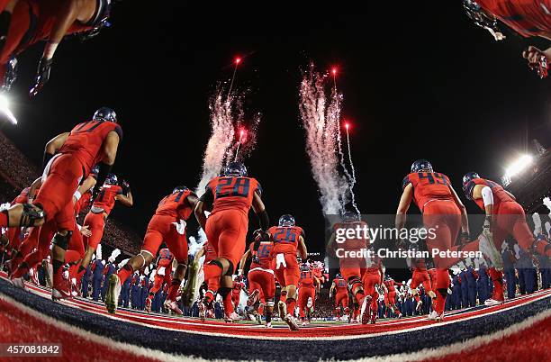 The Arizona Wildcats run out onto the field before the college football game aa\USC Trojans at Arizona Stadium on October 11, 2014 in Tucson, Arizona.