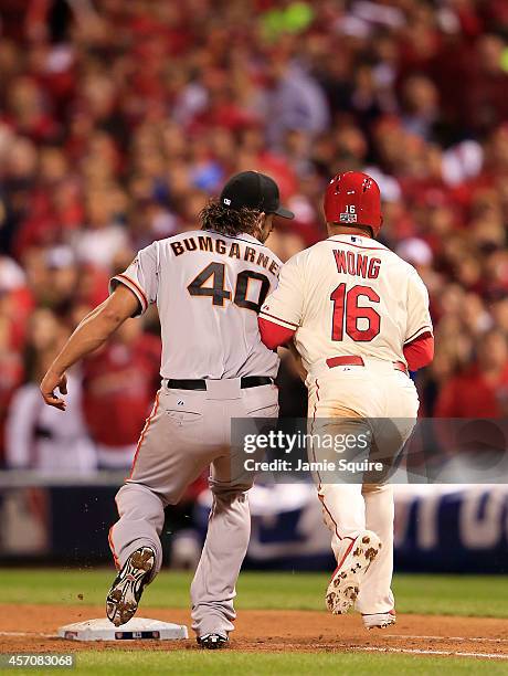 Madison Bumgarner of the San Francisco Giants tags Kolten Wong of the St. Louis Cardinals out in the seventh inning during Game One of the National...