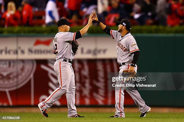 Gregor Blanco and Juan Perez of the San Francisco Giants celebrate their 3 to 0 win over the St. Louis Cardinals in Game One of the National League...