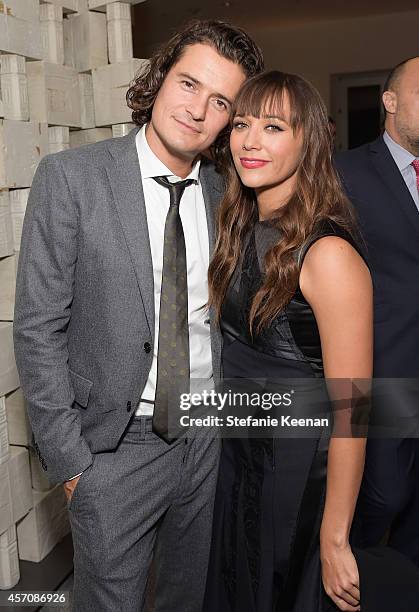 Actors Orlando Bloom, wearing Fall-Winter 2014/2015 New Light Grey Flannel Suit, Bianco Cotton Shirt and Silk Tie, and Rashida Jones, wearing...