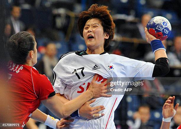 South Korea's Eun Hee Ryu vies with Serbia's Sanja Rajovic and Sanja Damnjanovic during the 2013 Women's Handball World Championship round of sixteen...