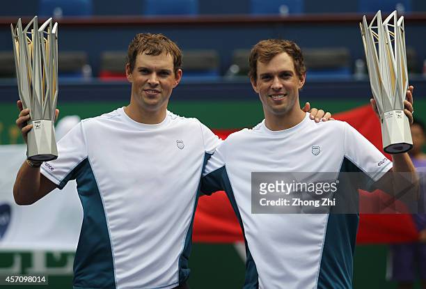 Bob Bryan of USA and Mike Bryan of USA victorious with trophies after winning their doubles final match against Julien Benneteau of France and...