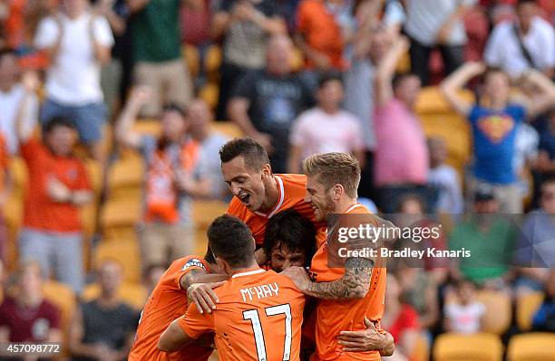 Thomas Broich of the Roar is congratulated by team mates after scoring a goal during the round one A-League match between the Brisbane Roar and...