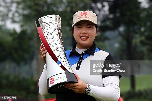 Shanshan Feng of China poses with the trophy after winning the Sime Darby LPGA on the final day at Kuala Lumpur Golf & Country Club on October 12,...