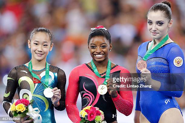 Silver medalist Bai Yawen of China, gold medalist Simone Biles of United States and Aliya Mustafina of Russia celebrates during the medal ceremony...