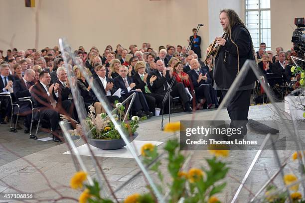 Jaron Lanier speaks to the audience as he plays the instrument of Laos 'Khaen' during the award ceremony at Paulskirche on October 12, 2014 in...