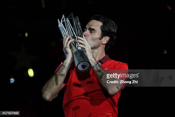Roger Federer of Switzerland celebrates with the trophy after winning the final against Gilles Simon of France during the day 8 of the Shanghai Rolex...