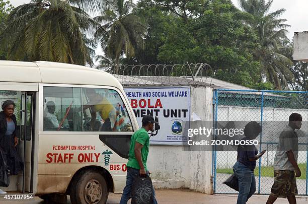 People walk on October 11, 2014 outside the recently opened Ebola Island Clinic in Monrovia. Health workers started a strike on October 6 to obtain a...