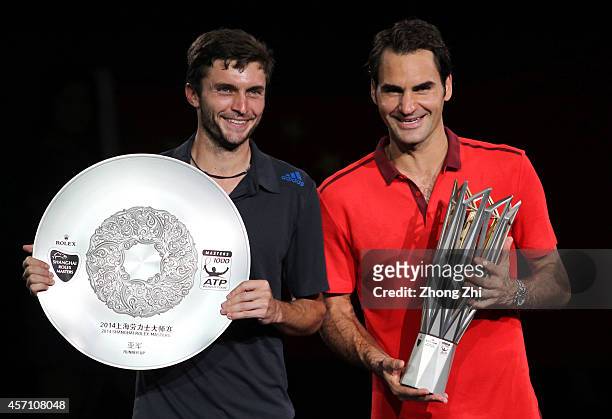 Shanghai Rolex Masters champion Roger Federer of Switzerland and runner-up Gilles Simon of France pose for photos with their trophies after the final...