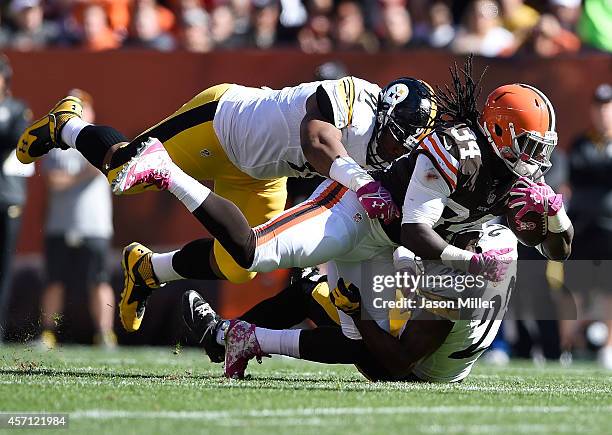 Isaiah Crowell of the Cleveland Browns gets tackled by Cameron Heyward and William Gay of the Pittsburgh Steelers during the second quarter at...