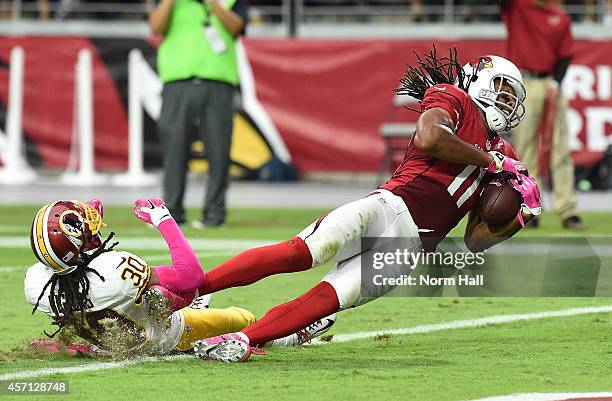Wide receiver Larry Fitzgerald of the Arizona Cardinals is hit in the end zone by cornerback E.J. Biggers of the Washington Redskins during the...