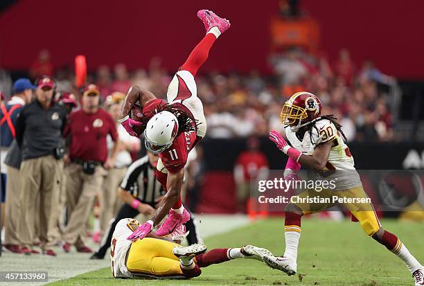 Wide receiver Larry Fitzgerald of the Arizona Cardinals leaps over strong safety Bashaud Breeland of the Washington Redskins after a reception during...