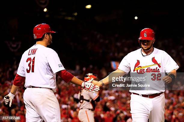 Matt Adams celebrates with Lance Lynn of the St. Louis Cardinals after he scored on a single by Randal Grichuk in the fourth inning against the San...