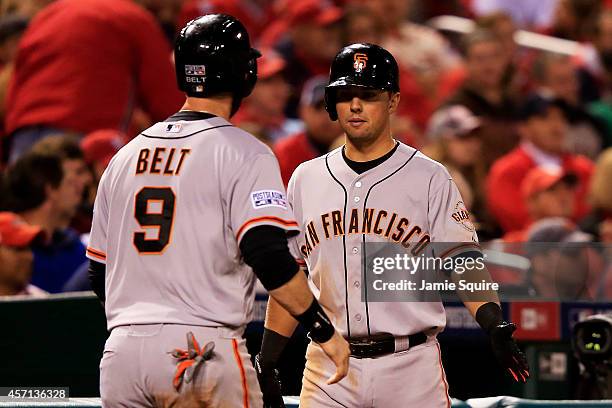 Brandon Belt of the San Francisco Giants celebtrates with Joe Panik after scoring in the fifth inning against the St. Louis Cardinals during Game Two...