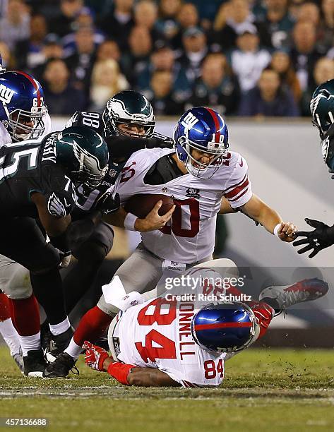 Quarterback Eli Manning of the New York Giants is sacked by Vinny Curry and Connor Barwin of the Philadelphia Eagles during the second quarter in a...