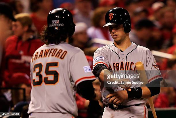 Brandon Crawford of the San Francisco Giants celebrates with Buster Posey after scoring on a single by Gregor Blanco in the seventh inning against...