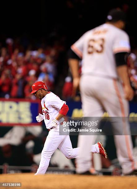 Oscar Taveras of the St. Louis Cardinals rounds the bases after hitting a solo home run in the seventh inning as Jean Machi of the San Francisco...