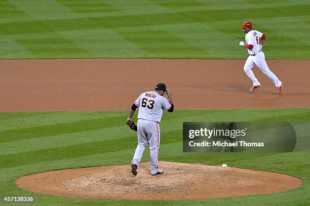 Oscar Taveras of the St. Louis Cardinals rounds the bases after hitting a solo home run in the seventh inning as Jean Machi of the San Francisco...