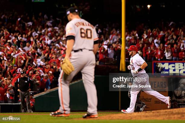 Matt Adams of the St. Louis Cardinals rounds the bases on his solo home run in the eighth inning as Hunter Strickland of the San Francisco Giants...