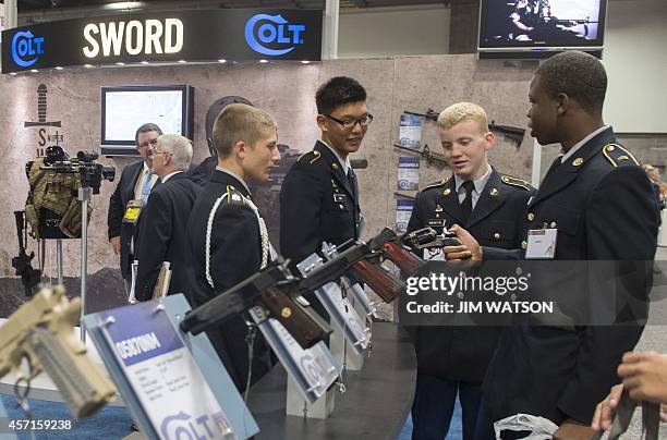 Some US Army cadets look over Colt Manufacturing LLC pistols during the Association of the United States Army Annual Meeting and Exposition in...