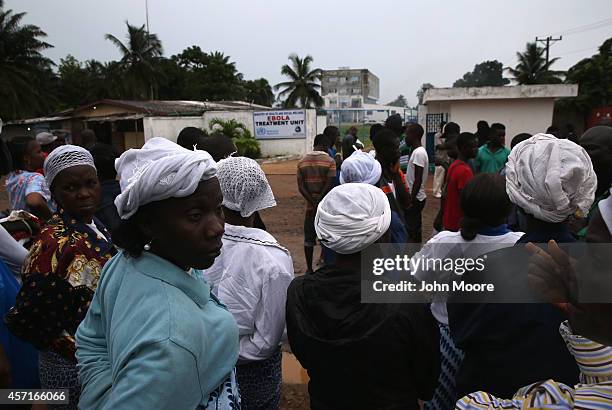 People gather outside the Island Clinic Ebola treatment center on October 13, 2014 in Monrovia, Liberia. A planned strike was averted as most nurses...